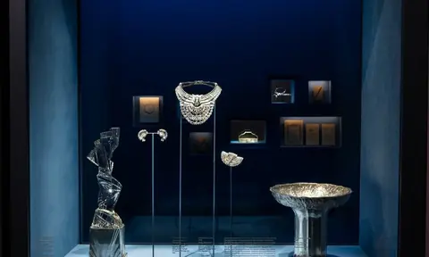 深蓝色展柜中陈列项饰、器皿、书册及多件小型文物。
