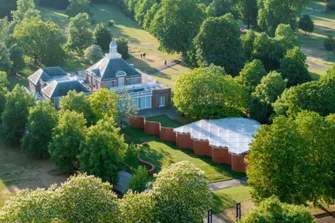 从空中俯瞰树木间的2026年 Serpentine Pavilion
