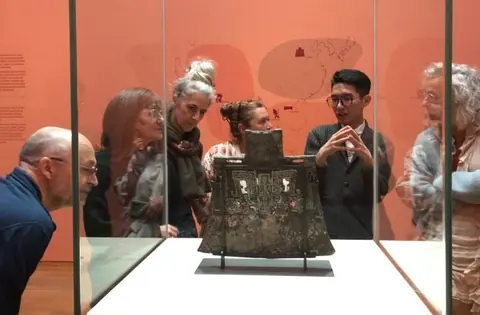 王庆龄在博物馆展柜前带领观众参观讲解