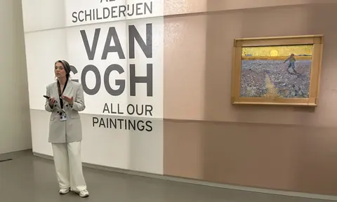 策展人Renske Cohen Tervaert在克勒勒-米勒博物馆的梵高全藏展开幕现场讲解，身旁为《播种者》