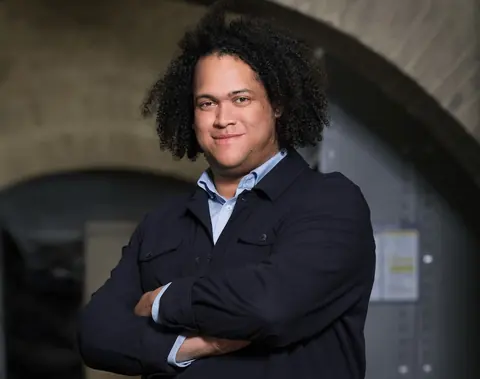 策展人Cédric Fauq抱臂站立的肖像