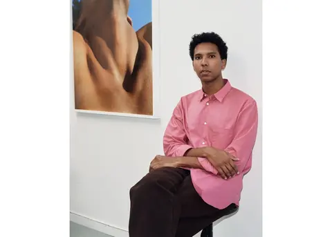 摄影与影像艺术家 Tyler Mitchell 坐在一幅摄影作品前