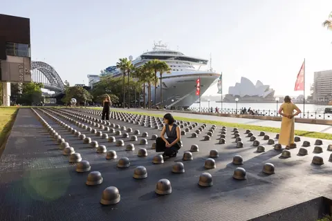 艾未未 2026 年作品《Mushrooms》，铸铁战斗头盔在悉尼 MCA Australia 馆外排列