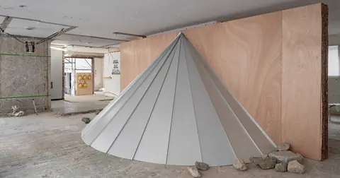首尔裸露混凝土空间内由钢制锥体穿过木制圆柱的雕塑装置